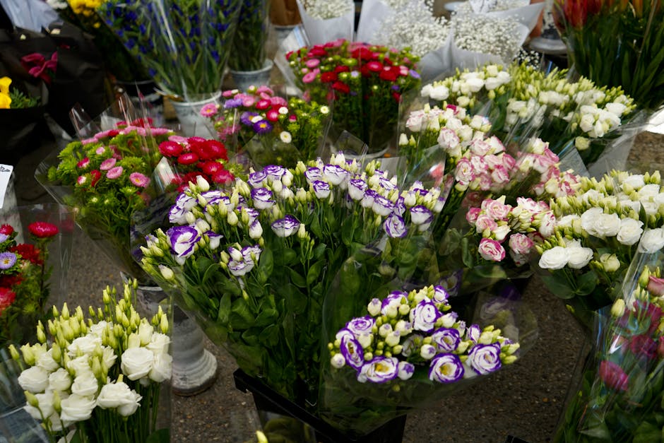 A vibrant array of fresh floral bouquets displayed on a countertop at a florist shop, showcasing a variety of flowers including purple and white eustoma, pink and white roses, small red, purple, and w